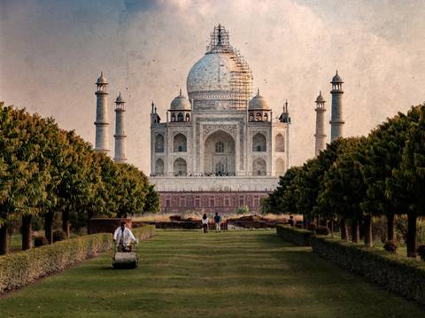 Taj Mahal viewed from a distance with people in the foreground.