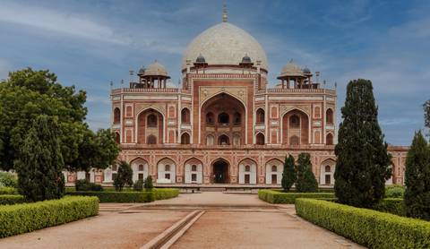       Humayun's Tomb surrounded by gardens with a clear sky overhead.
  
