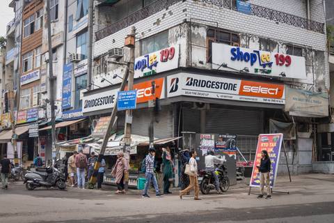       Busy street scene showcasing a corner with multiple shops and signage.
  