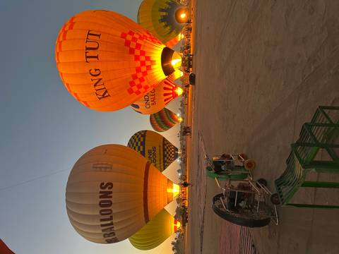       Hot air balloons being inflated during early morning.
  