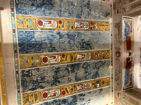       Close-up of ancient Egyptian hieroglyphs painted on a ceiling.
  