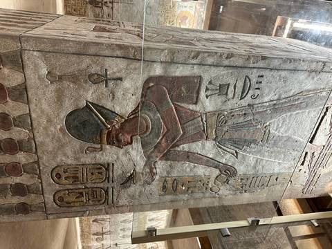       Carved Egyptian figure with hieroglyphs on a wall.
  