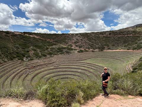 Person posing in front of circular terraces at Moray.