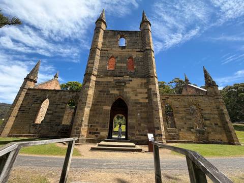       Historic ruins with large windows surrounded by grass.
  