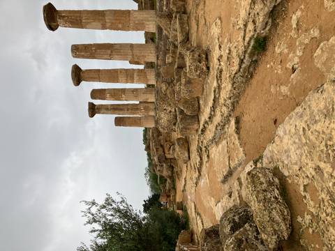 Ancient Roman temple ruins in a barren landscape.