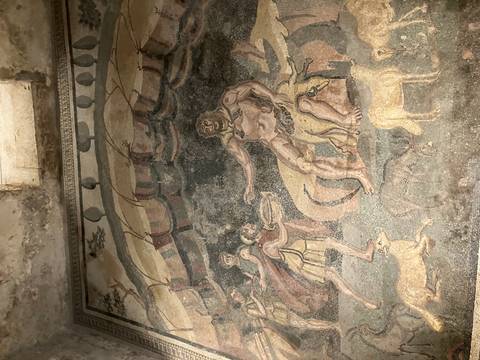 Mosaic depicting ancient figures and animals.