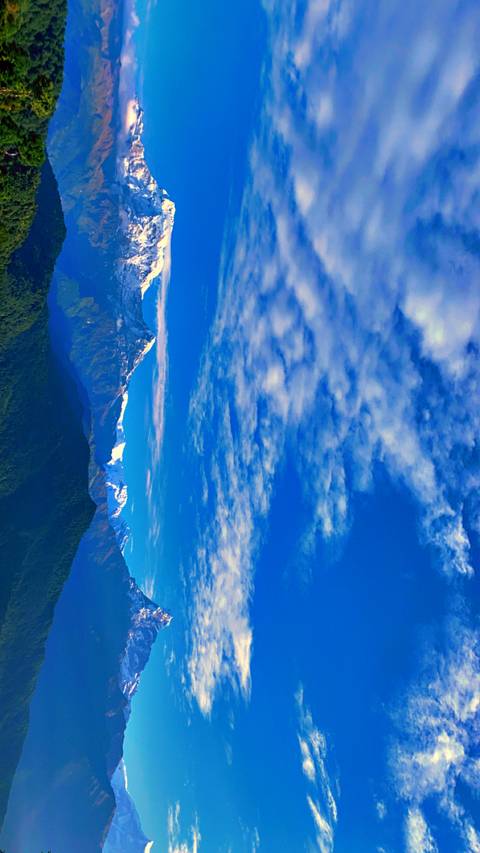 Scenic view of snow-capped mountains under a blue sky.