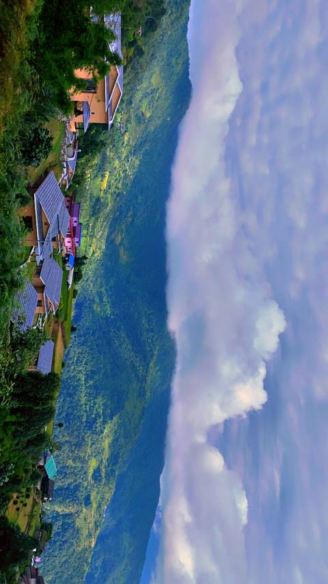 Small village at the foot of lush green hills.