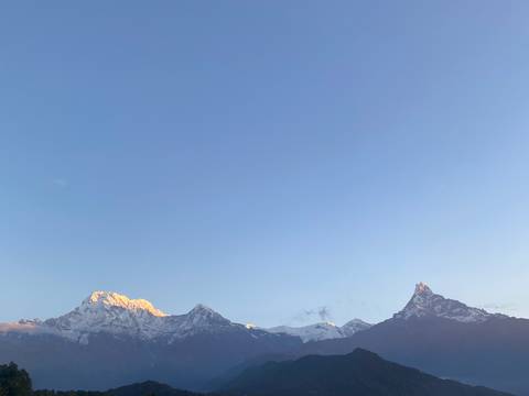 Clear view of mountain peaks at sunrise.