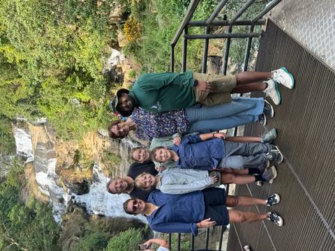 Group posing in front of a waterfall.