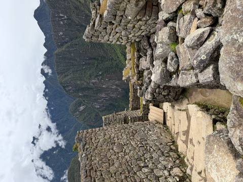 Stone pathways and ruins with mountain backdrop at Machu Picchu.
