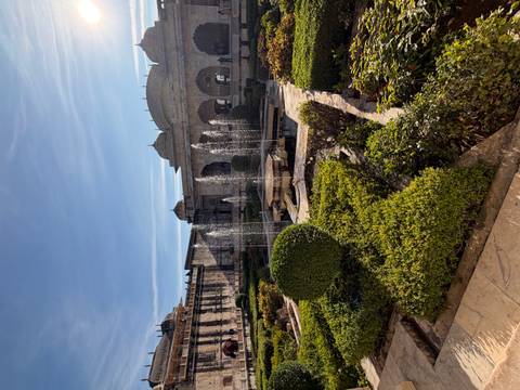 Fountain and gardens with historic architecture.