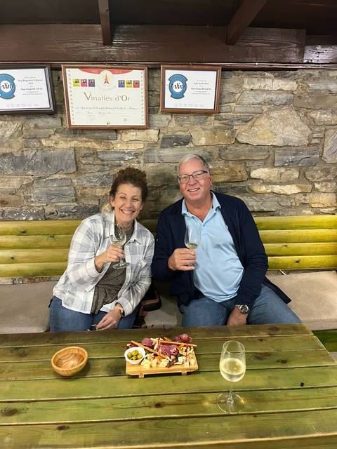       A couple enjoying a wine tasting indoors.
  