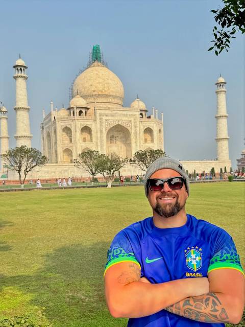       Person posing in front of the Taj Mahal.
  