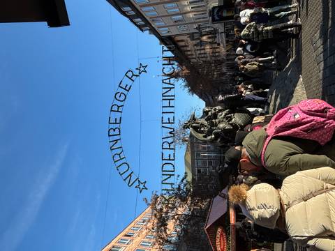       Crowded street with a sign for 'NURNBERGER KINDERWEIHNACHT' above.
  