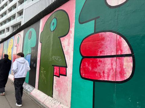       Section of the Berlin Wall with colorful artwork.
  