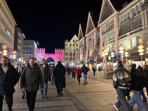       Busy street with festive lights and decorations at night.
  