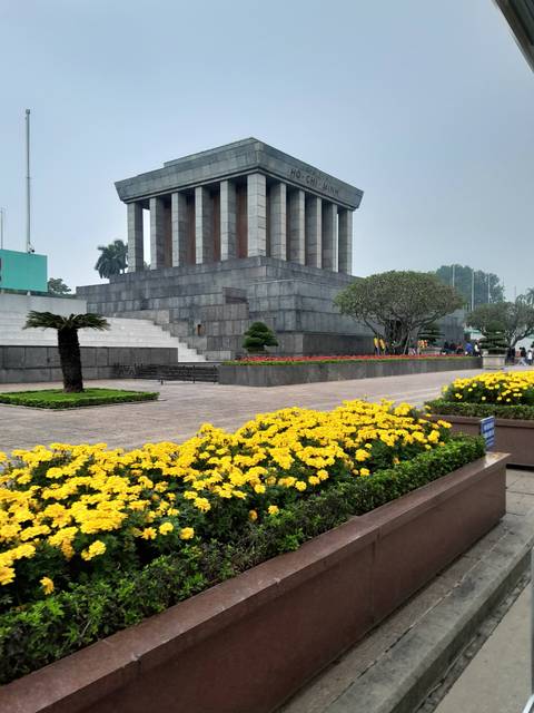 Mausoleum with vibrant floral gardens and stairs.