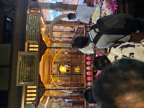 Interior of a crowded temple with people in prayer.