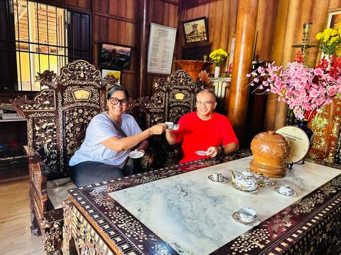       Couple enjoying tea in a traditionally decorated room.
  
