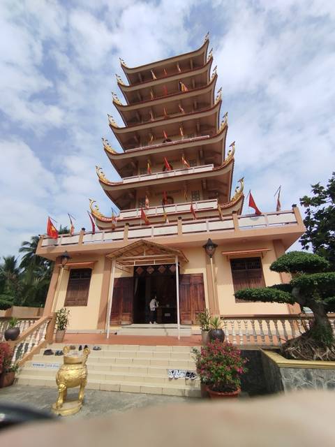       Pagoda with multiple tiers and flags in Vietnam.
  