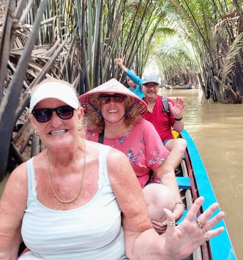       Tourists enjoying a boat ride through dense trees.
  