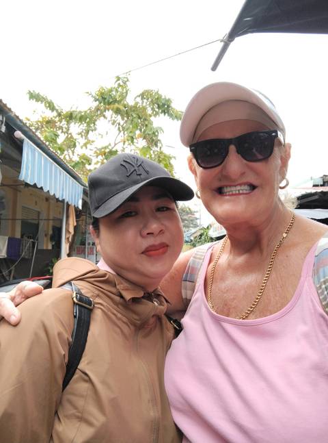       Two women posing for a picture on a street.
  