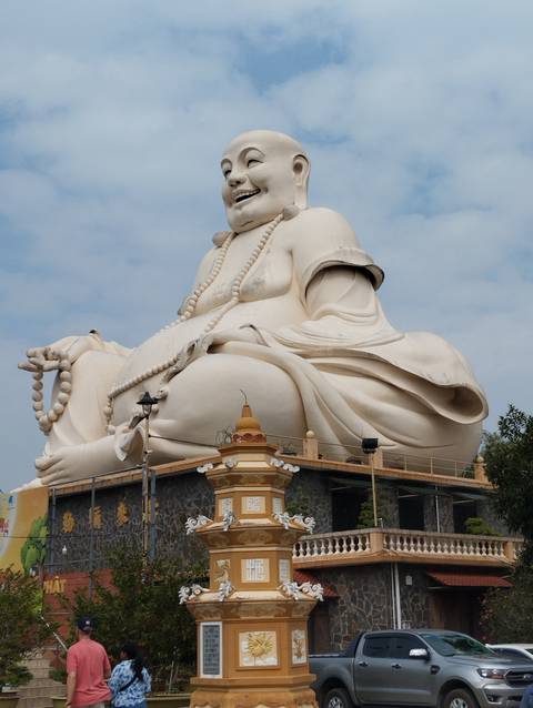       A large white Buddha statue with intricate details.
  