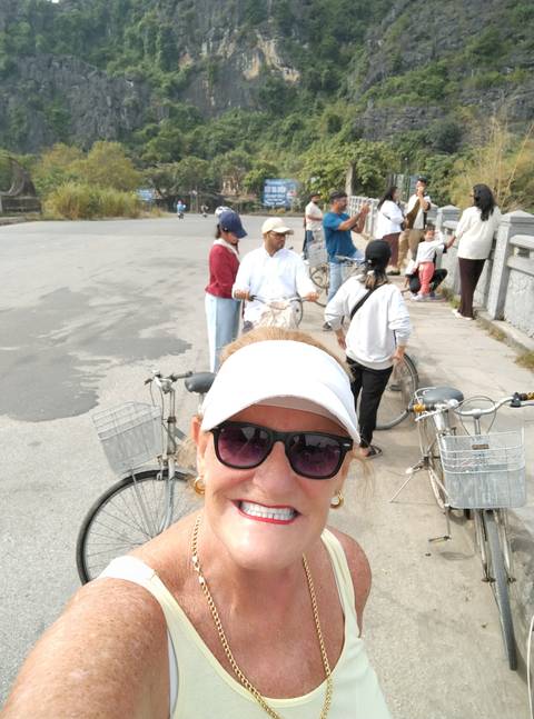       Group of people with bicycles on a road.
  