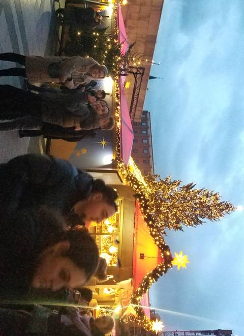 Christmas market with people and a lit tree.