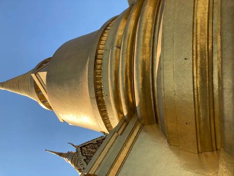Golden stupa viewed from below against a clear sky.
