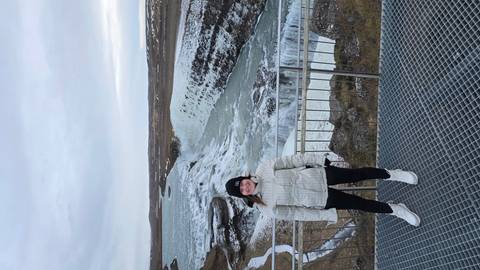       Person standing in front of the frozen Gullfoss waterfall.
  