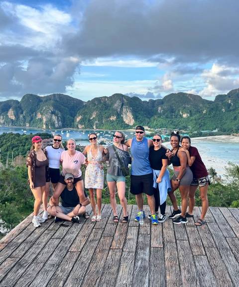 Group photo with a scenic view of Ko Phi Phi's cliffs and bay.