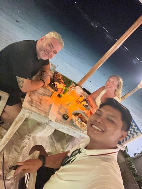 People dining at a beachside restaurant during night.