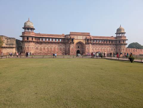 Visitors at a historical fort with large courtyards and towers.
