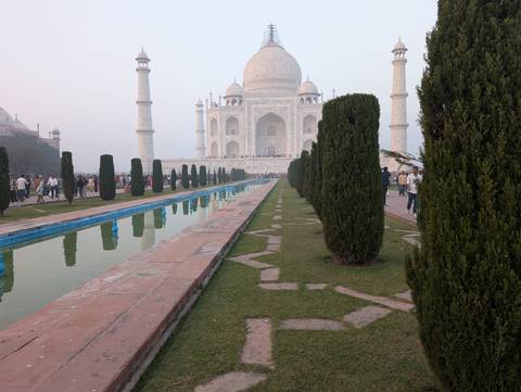 Lush gardens with reflecting pools leading to the Taj Mahal.