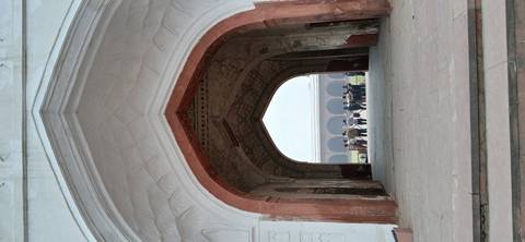 Archway leading to an open courtyard with people.