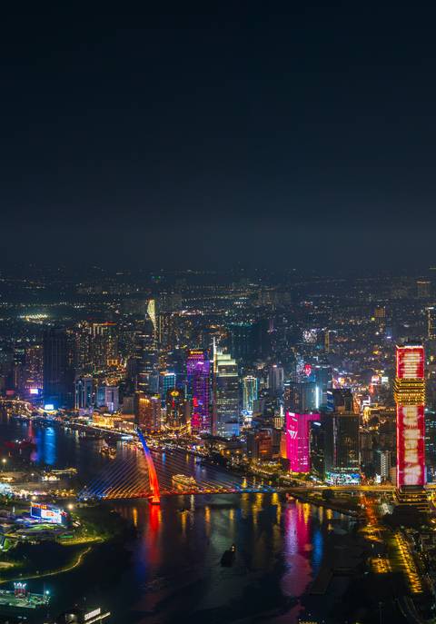       Night view of a bustling city skyline with brightly lit buildings.
  