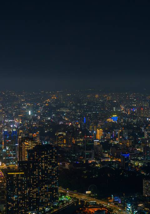       Cityscape at night with glowing urban lights.
  