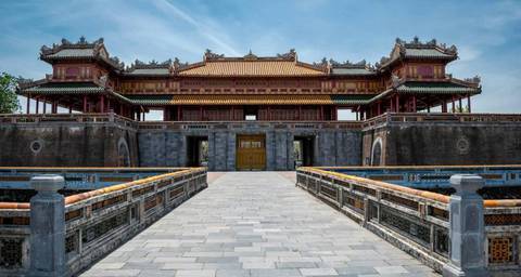       Ornate gateway of Hue Imperial City surrounded by a moat.
  