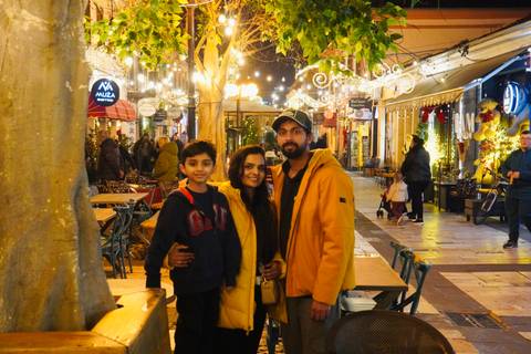 Family posing in a bustling street with decorations and cafes.