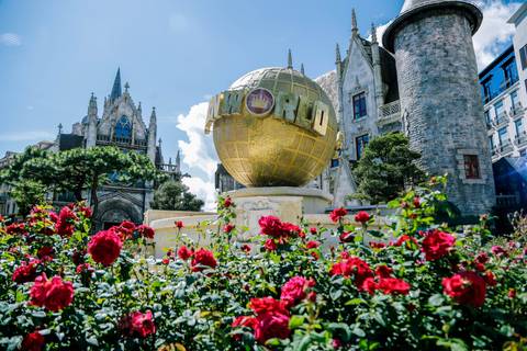       Theme park with a large globe sculpture and flowers.
  