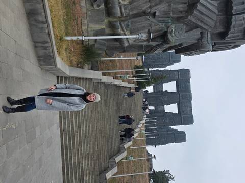 Person standing at the bottom of a tall monument staircase.