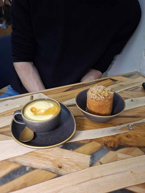       A cup of coffee and a dessert on a table.
  