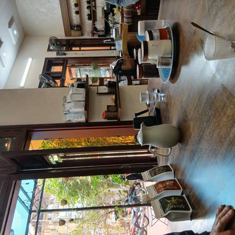 Interior of a cafe with cups and coffee equipment on a table.