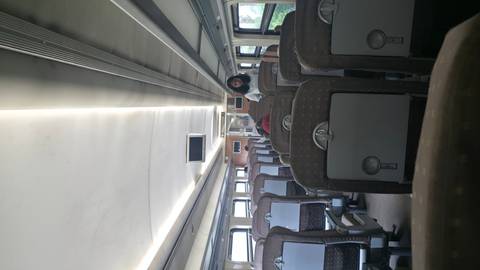       Interior of a train carriage with passengers.
  