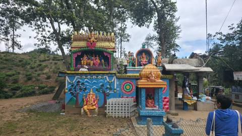 Colorful temple in a park setting with people.