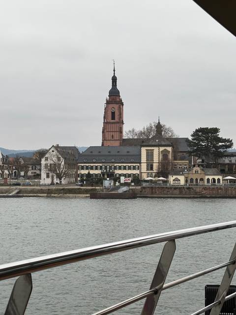 Riverside view with historic buildings and a church tower.