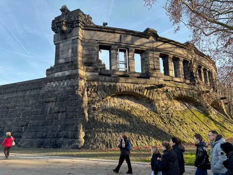 Tourists walking along the ruins of a historical structure.