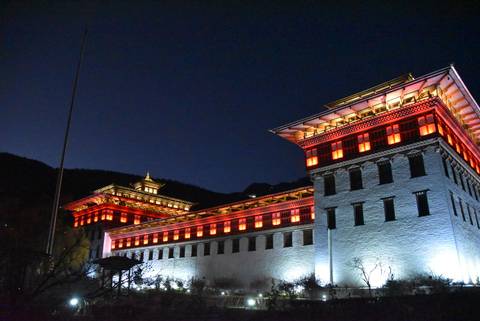 Illuminated traditional building at night in Bhutan.
